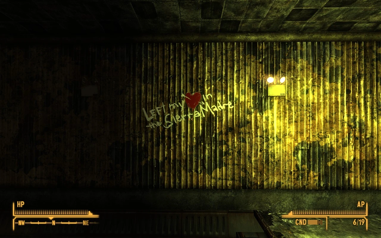 Graffiti on a grungy, yellow-stained metal wall reads "Left my heart in the Sierra Madre" with a red heart symbol replacing the word "heart."