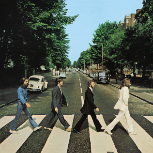 Cover of Abbey Road: the Beatles, in side view, crossing the street in single file.